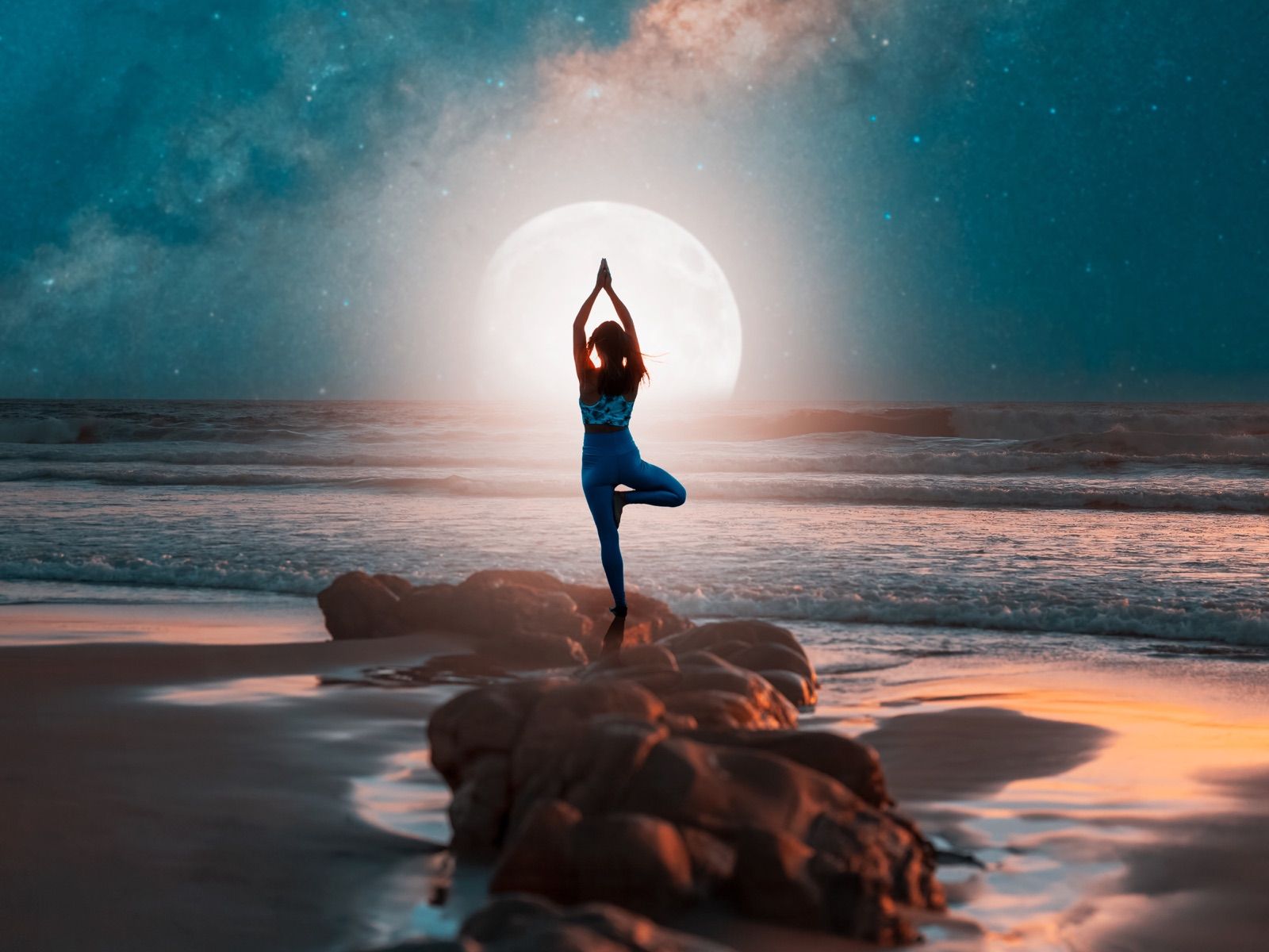 Frau in der Baumhaltung am Meer vor dem Vollmond und der Milchstrasse