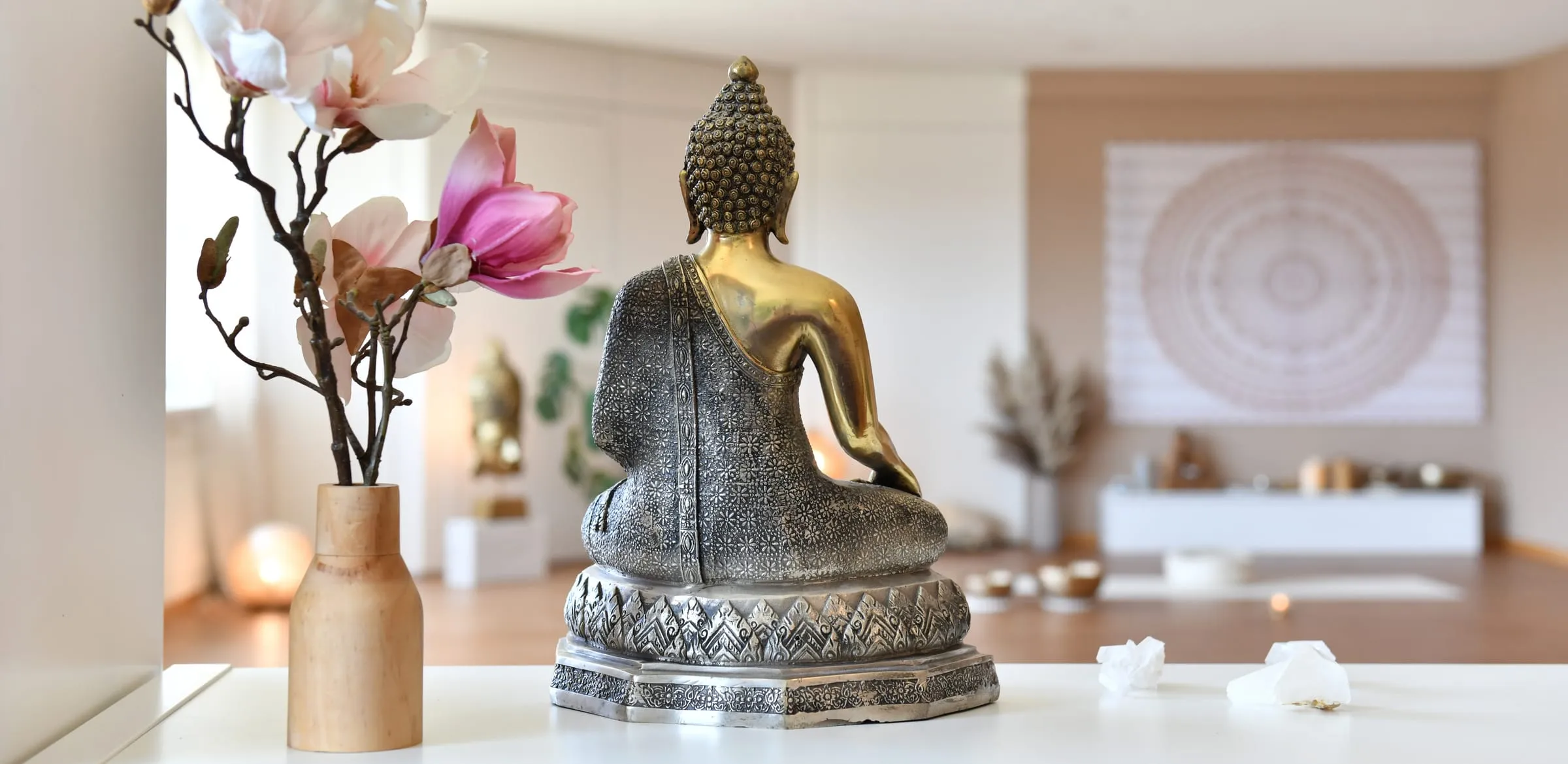 Buddha-Figur und Blumen im Yogaraum